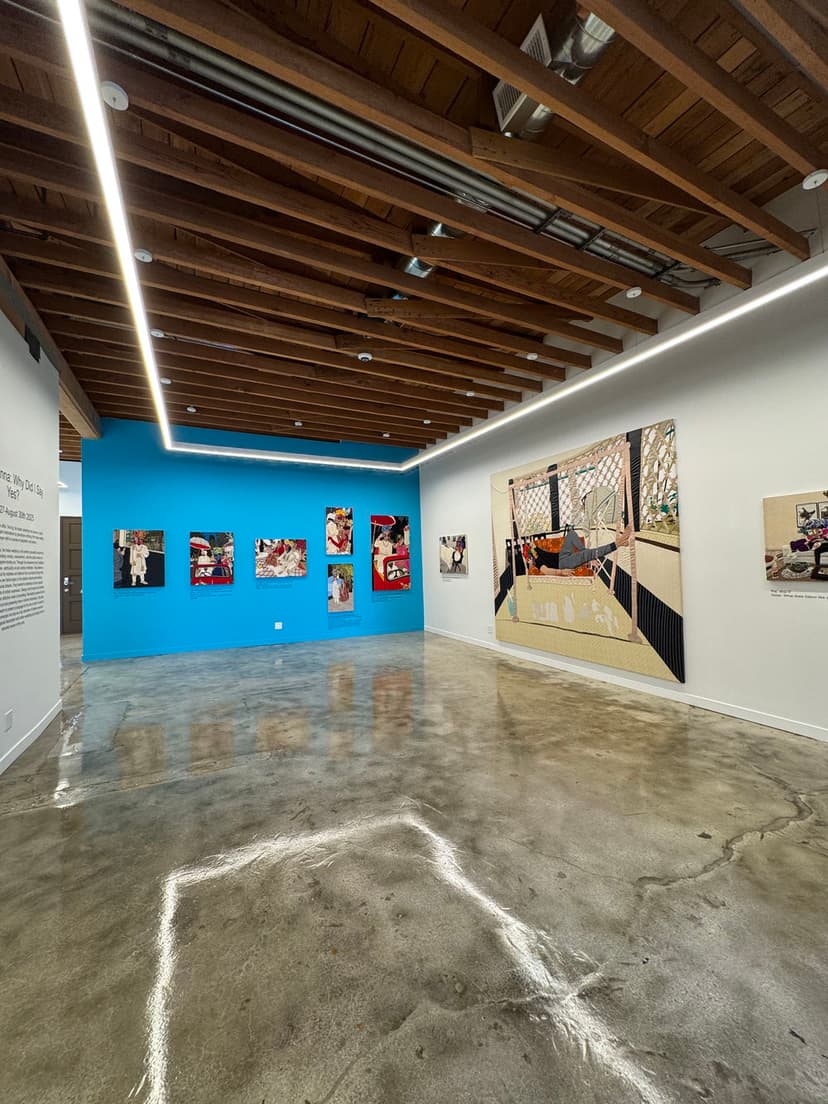 Art gallery interior showcasing vibrant walls, modern ceiling, and polished concrete floor.